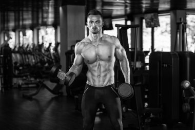 Genç adam için pazı Dumbbells ile egzersiz yaparak