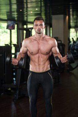 Genç adam için pazı Dumbbells ile egzersiz yaparak