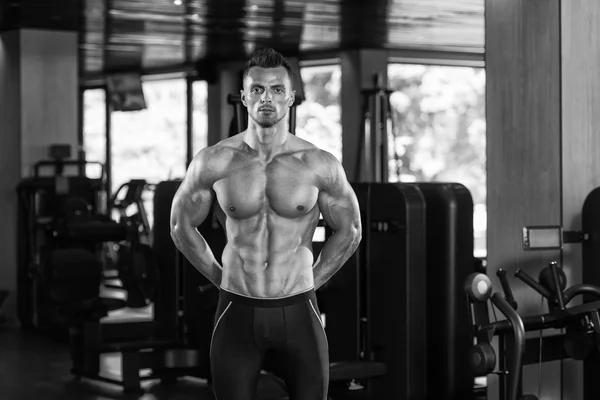 Hombre en el gimnasio mostrando su cuerpo bien entrenado —  Fotos de Stock