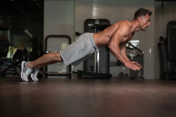 Fisiculturista fazendo flexões extrema no chão — Fotografia de Stock