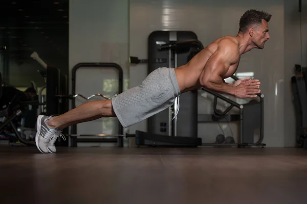 Bodybuilder doen Extreme push-ups op verdieping — Stockfoto