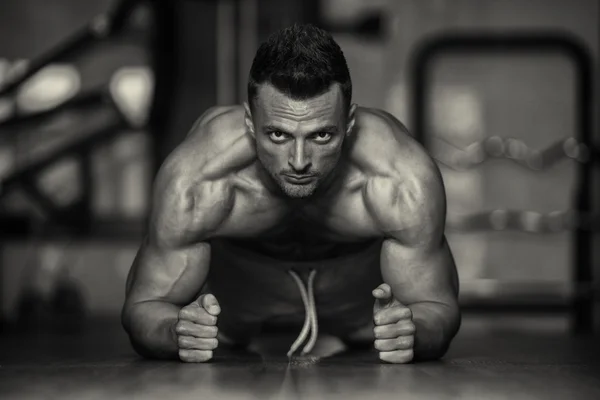 Joven haciendo push ups en el suelo — Foto de Stock