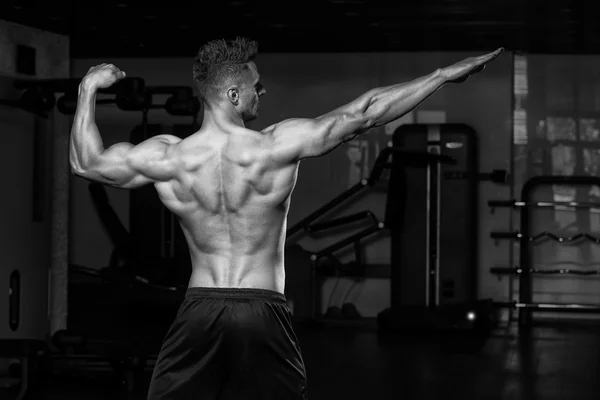 Hombres musculares flexionando los músculos en el gimnasio — Foto de Stock