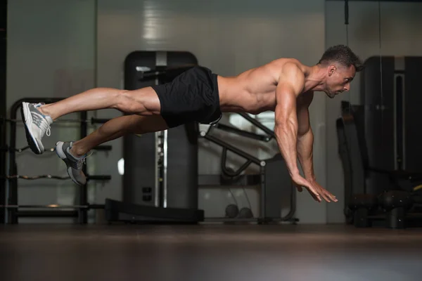 Jonge Man doen Extreme push-ups op verdieping — Stockfoto