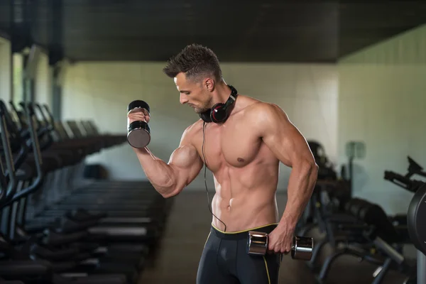 Jovem fazendo exercício para bíceps com halteres — Fotografia de Stock