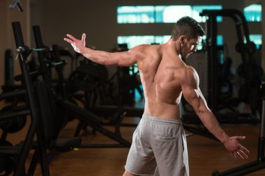 Spor salonunda genç bir adamın pazı poz