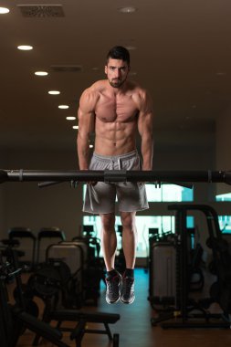 Triceps dips yapıyor egzersiz genç vücut geliştirmeci üzerinde Bar