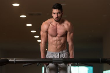 Triceps dips yapıyor egzersiz genç vücut geliştirmeci üzerinde Bar