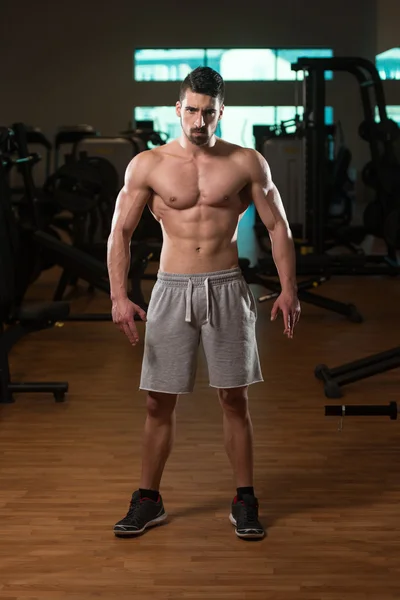 Joven culturista posando en el gimnasio — Foto de Stock