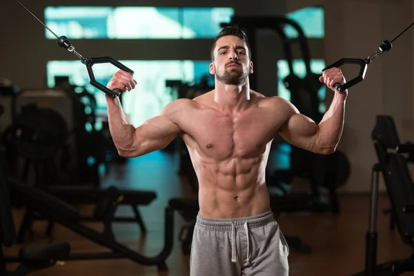 Junge Bodybuilderin trainiert Bizeps am Seilzug — Stockfoto