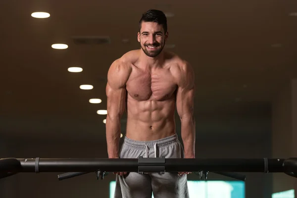 Joven culturista haciendo ejercicio tríceps haciendo saltos en la barra —  Fotos de Stock