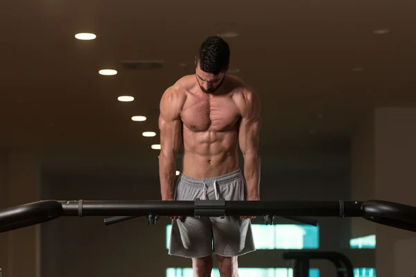 Junger Bodybuilder, der Trizeps trainiert und Dips am Barren macht — Stockfoto