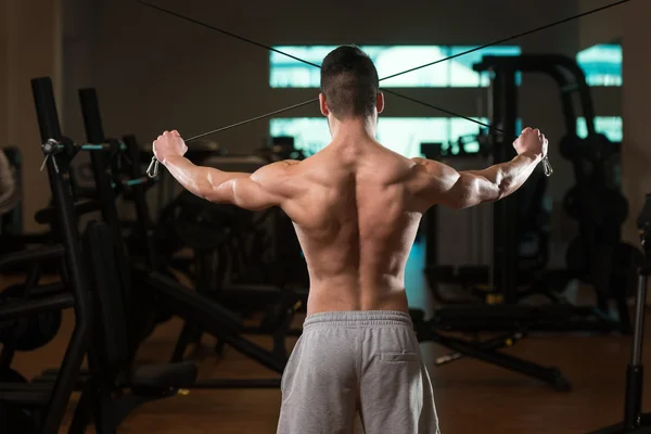 Bodybuilder Exercising Shoulders On Cable Machine — Stock Photo, Image