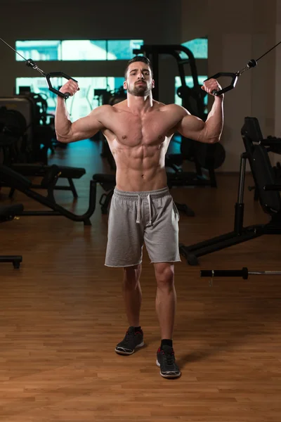 Junge Bodybuilderin trainiert Bizeps am Seilzug — Stockfoto