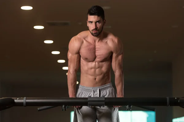 Triceps dips yapıyor egzersiz genç vücut geliştirmeci üzerinde Bar — Stok fotoğraf
