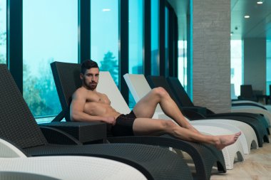 Bir güneşlenme üzerinde yatan genç adam