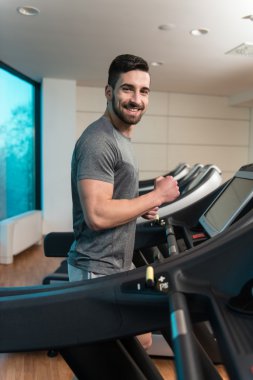 Genç adam bir koşu bandı üzerinde egzersiz