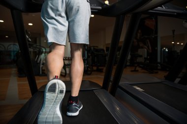 Yakın çekim adam ayakta koşu bandı