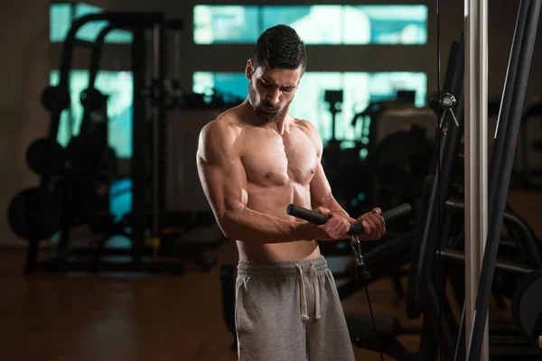 Joven ejercitando bíceps en el gimnasio — Foto de Stock