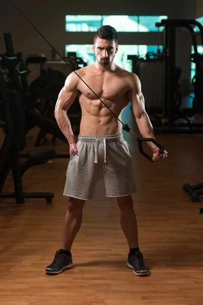 Junger Mann trainiert Trizeps im Fitnessstudio — Stockfoto