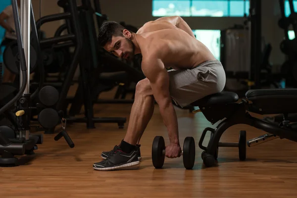 Mann im Fitnessstudio trainiert Bizeps mit Hantel — Stockfoto