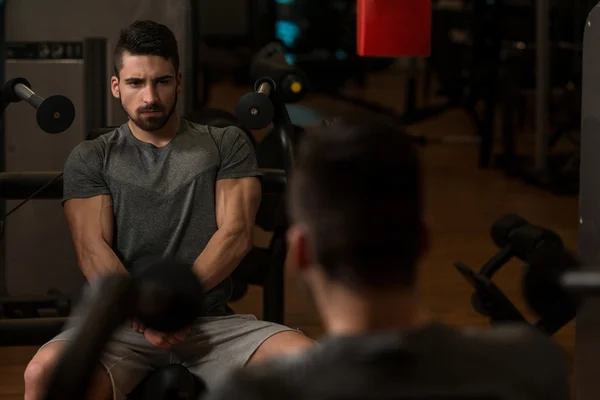 Bodybuilder zeigt seine Muskeln und posiert im Fitnessstudio — Stockfoto