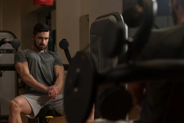 Uomo atletico mostrando i suoi muscoli in palestra — Foto Stock