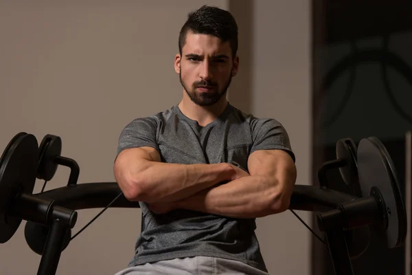 Retrato de un joven atlético muscular posando mientras está sentado —  Fotos de Stock