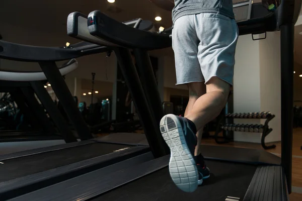 Gros plan Pieds d'homme sur tapis roulant — Photo