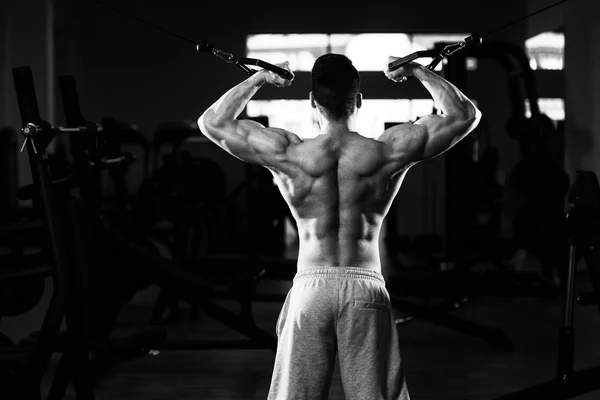 Musculoso hombre flexionando los músculos en el gimnasio —  Fotos de Stock