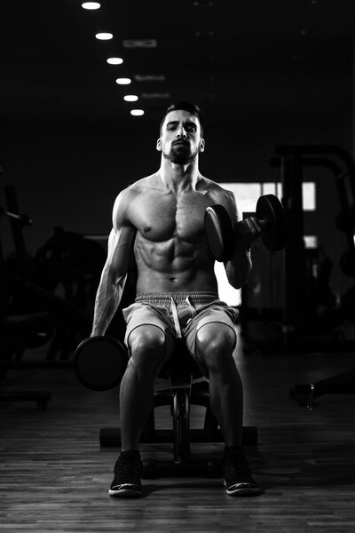 Man In The Gym Exercising Biceps With Dumbbell