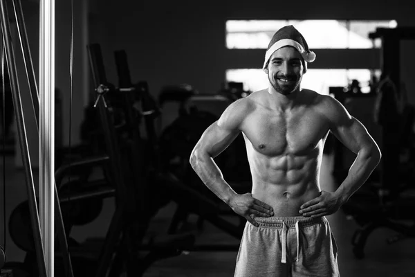 肌肉男在健身房戴圣诞老人帽子 — 图库照片