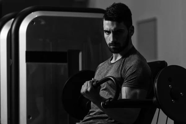 Unga kroppsbyggare tränar Biceps på maskin — Stockfoto