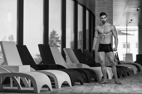 Young Man Flexing Muscles At Sun Lounger — Stock Photo, Image