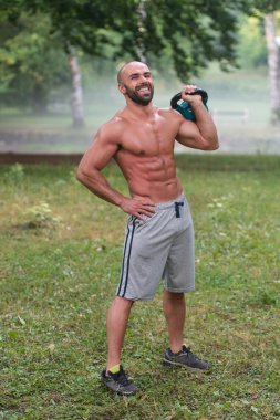 Yakışıklı kaslı adam su ısıtıcısı çan Holding