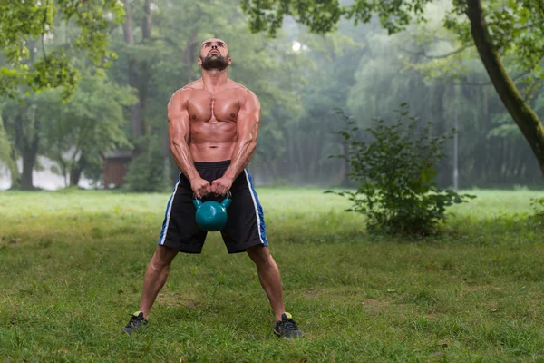 Bonito homem muscular segurando Kettle Bell — Fotografia de Stock