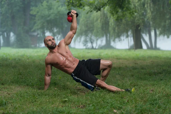 Ginocchiarsi muscolare uomo esercizio con kettlebells — Foto Stock