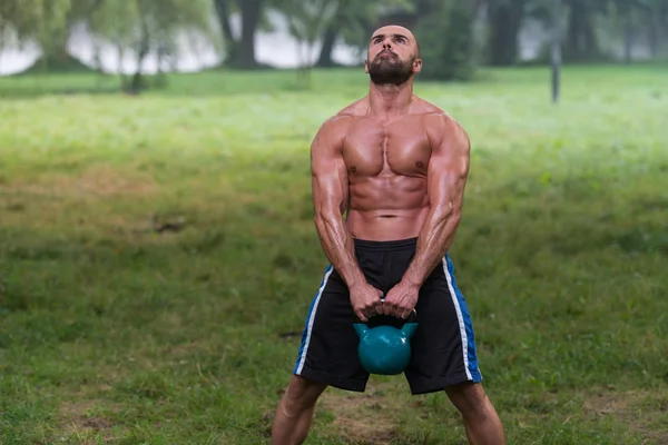 Atleta masculino atraente realizando um balanço Kettle-Bell — Fotografia de Stock