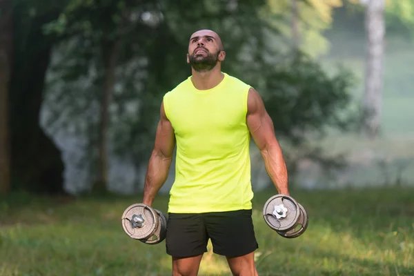 Hombre joven haciendo ejercicio para bíceps al aire libre Entrenamiento —  Fotos de Stock