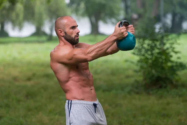 フィットネス ケトルベル スイング運動男性トレーニング屋外 — ストック写真