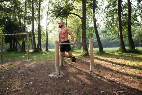 Treino de homem muscular em bares no ginásio ao ar livre — Fotografia de Stock