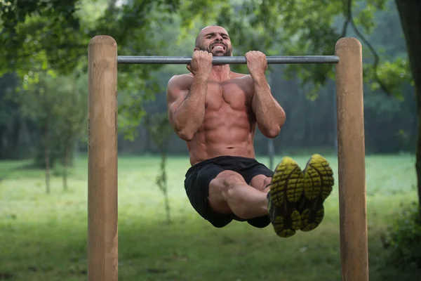 Muscular Man Workout On Bars In Outdoor Gym — Stock Photo, Image