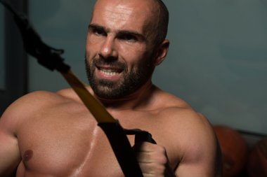 Trx Fitness askıları ile genç çekici adam eğitim