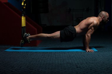 Trx Fitness askıları ile genç çekici adam eğitim