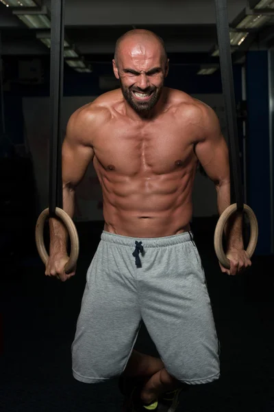 Muscular hombre sosteniendo dos anillos — Foto de Stock