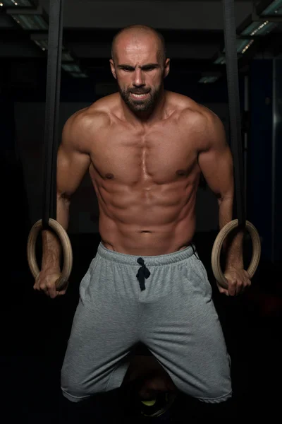 Muscular hombre sosteniendo dos anillos — Foto de Stock