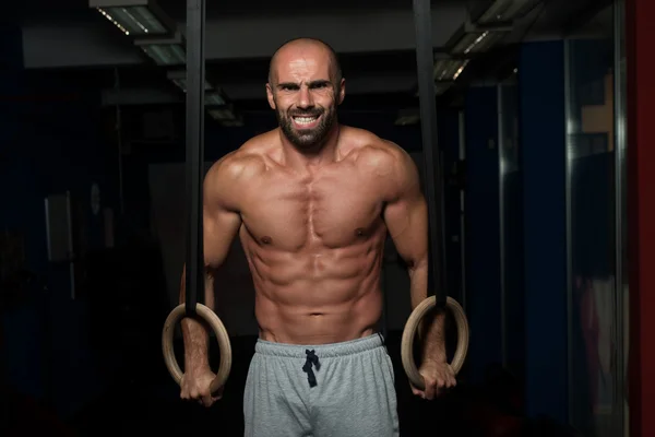 Muscular Athlete Hanging On Gymnastic Rings — Stock Photo, Image