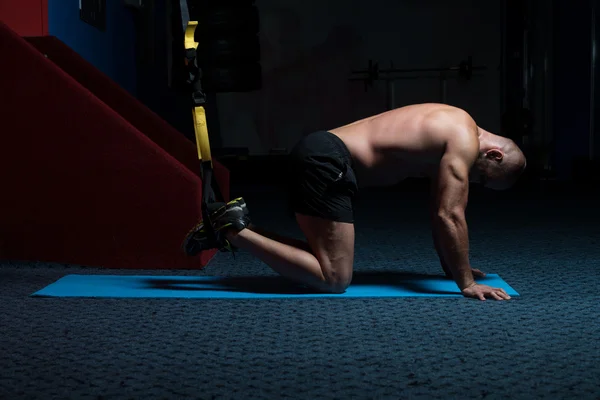 Entrenamiento de hombre atractivo joven con correas de fitness Trx —  Fotos de Stock