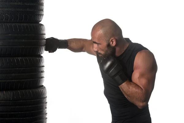 Boxeador está golpeando neumático sobre fondo blanco aislado — Foto de Stock