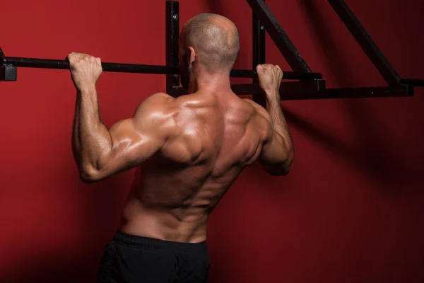 Mužský sportovec dělá pull ups — Stock fotografie